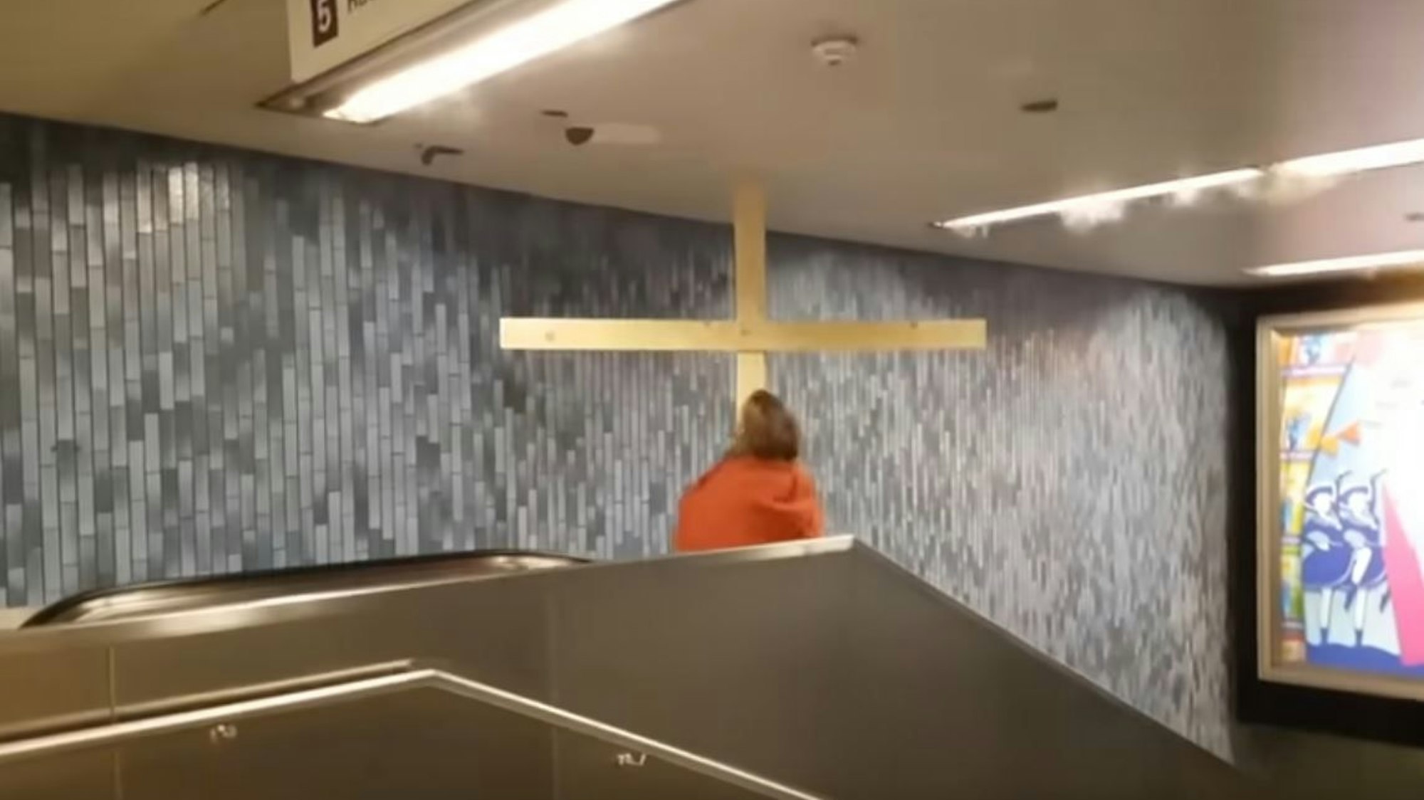 Ausschnitt aus einem Youtube-Video, das einen 'Jesus' auf der Rolltreppe in der KVB-Haltestelle Dom/Hauptbahnhof zeigt.