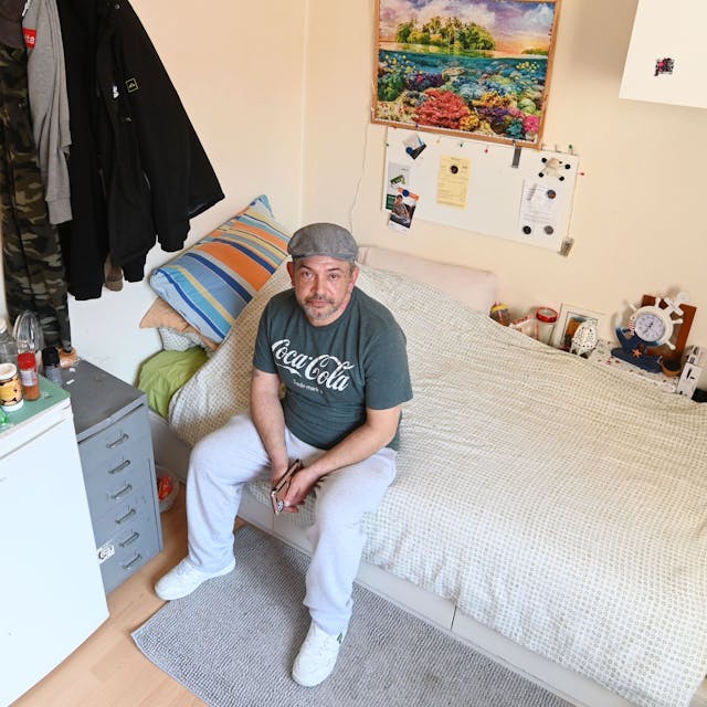 Christian Semerao sitzt auf dem Bett seines Zimmers in der Notschlafstelle für Drogensüchtige in der Cranachstraße.
