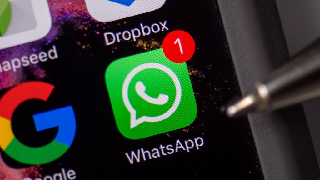 Das WhatsApp-Logo ist auf dem Smartphone-Display eines iPhones zu sehen (Symbolbild).