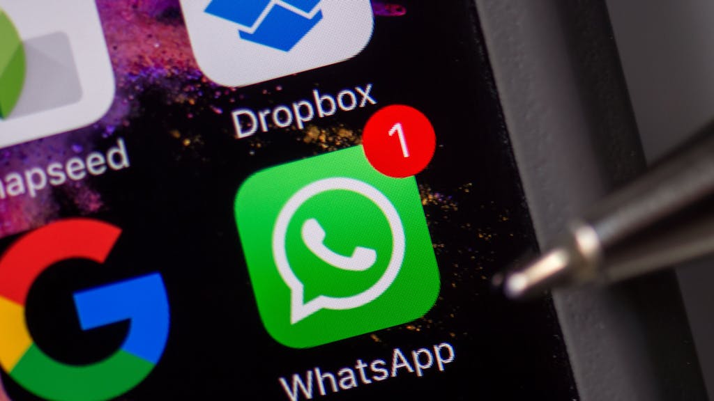 Das WhatsApp-Logo ist auf dem Smartphone-Display eines iPhones zu sehen (Symbolbild).