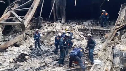 Einsatzkräfte in den Trümmern der Crocus City Hall in Moskau