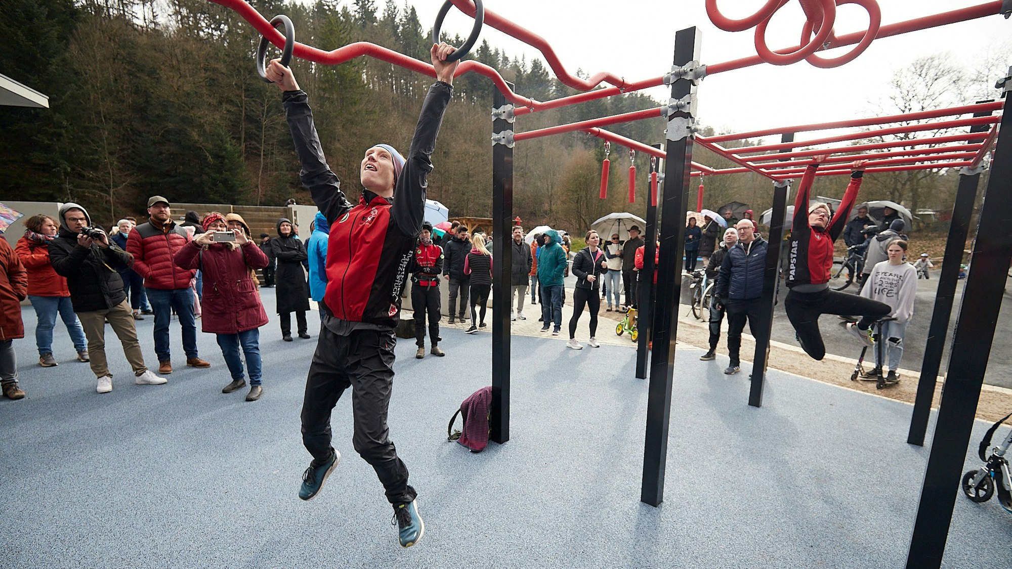 Lars Holder und Milena Vogel vom TuS Schleiden hängen an Ringen und Stangen an einem Kraftparcours.