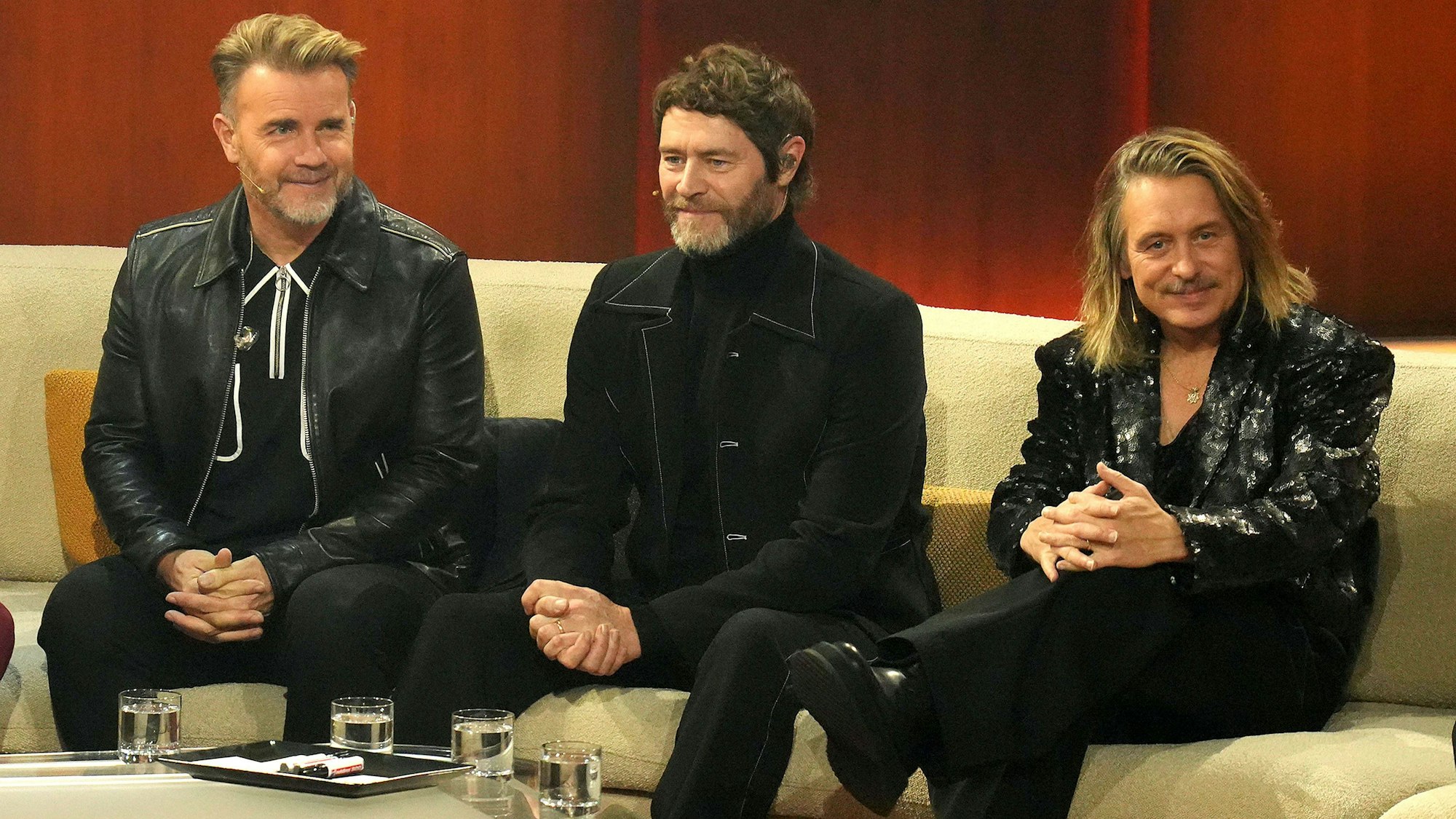 Gary Barlow, Howard Donald und Mark Owen sitzen bei „Wetten, dass...?“ auf der Couch.