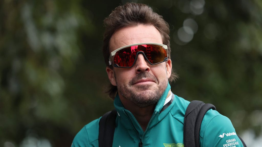 Fernando Alonso kommt mit lässiger Sonnenbrille am Fahrerlager an.