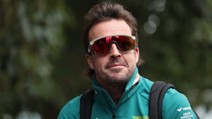 Fernando Alonso kommt mit lässiger Sonnenbrille am Fahrerlager an.