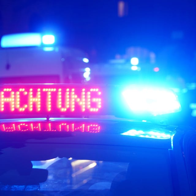 Das Bild zeigt einen Polizeiwagen in der Dunkelheit mit eingeschaltetem Blaulicht.&nbsp;