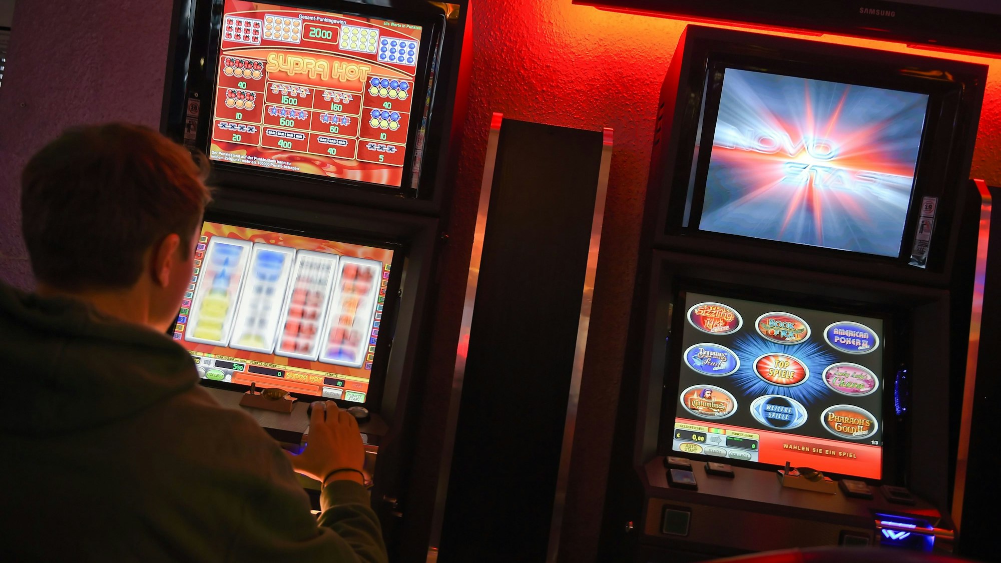 Ein Mann sitzt an einem Glücksspielautomaten