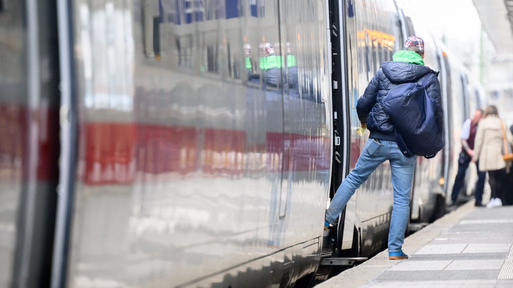 Ein Mann steht im Hauptbahnhof Hannover an einem ICE.