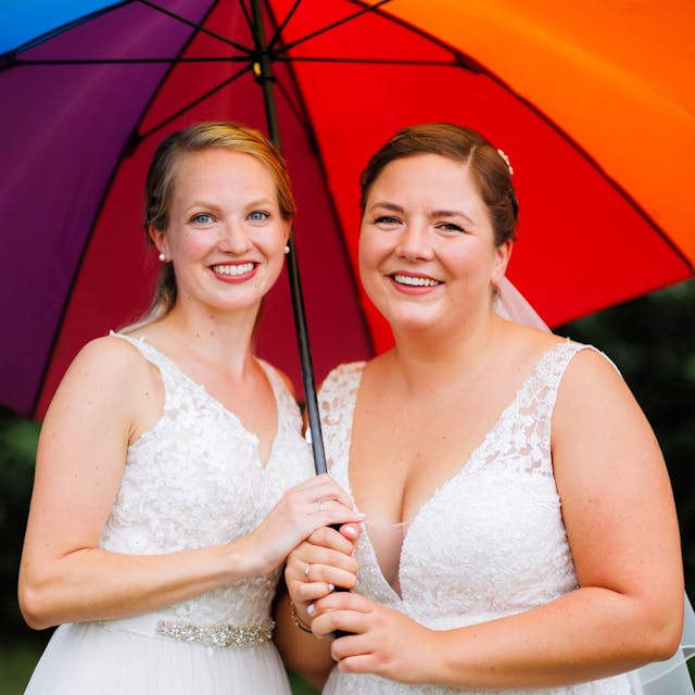 Laura und Christel Wendeler halten einen Regenbogen-Regenschirm.