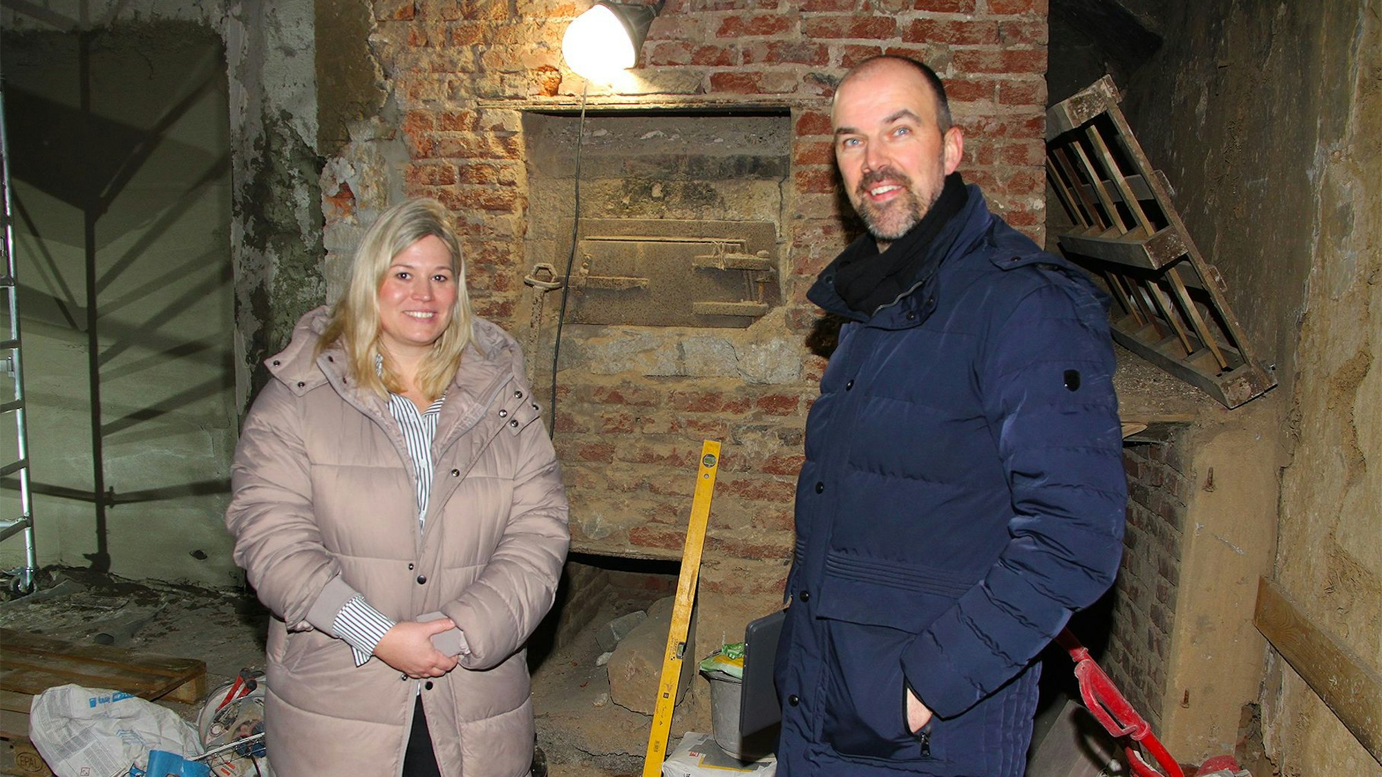 Bürgermeisterin Jennifer Meuren und Verwaltungsmitarbeiter Guido Waters stehen am historischen Königswinterer Backofen in der Baustelle der ehemaligen Küche des Barockhauses.
