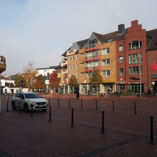 Der Marktplatz in Pulheim, links das Kunstwerk „Hahn im Korb“.