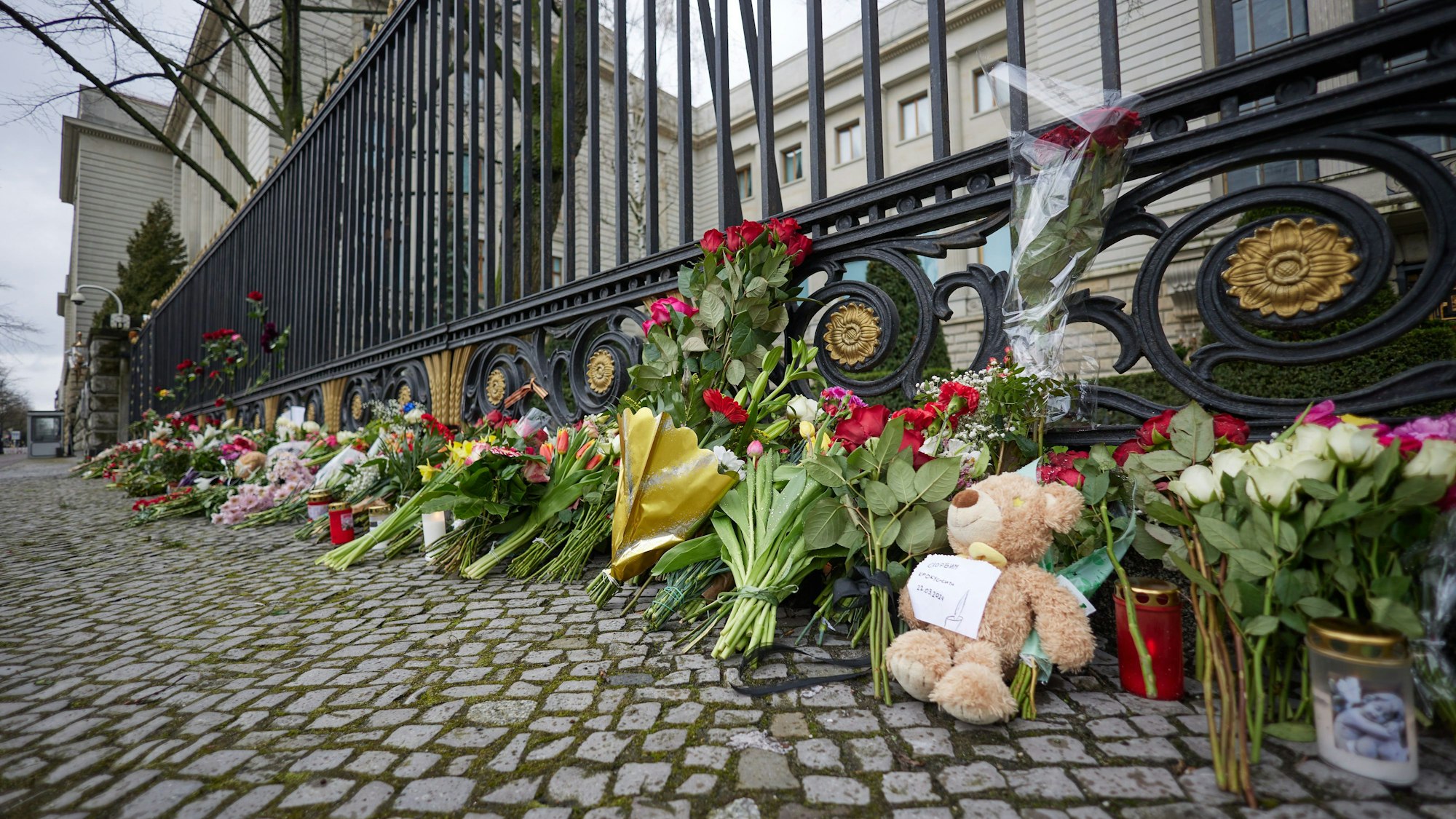 Blumen und ein Teddybär liegen am Zaun der russischen Botschaft, die nach dem Anschlag in Moskau dort abgelegt wurden. Bei dem Terroranschlag auf das Veranstaltungszentrum Crocus City Hall am Stadtrand von Moskau ist die Zahl der Toten nach Angaben der Ermittler auf mehr als 130 gestiegen.