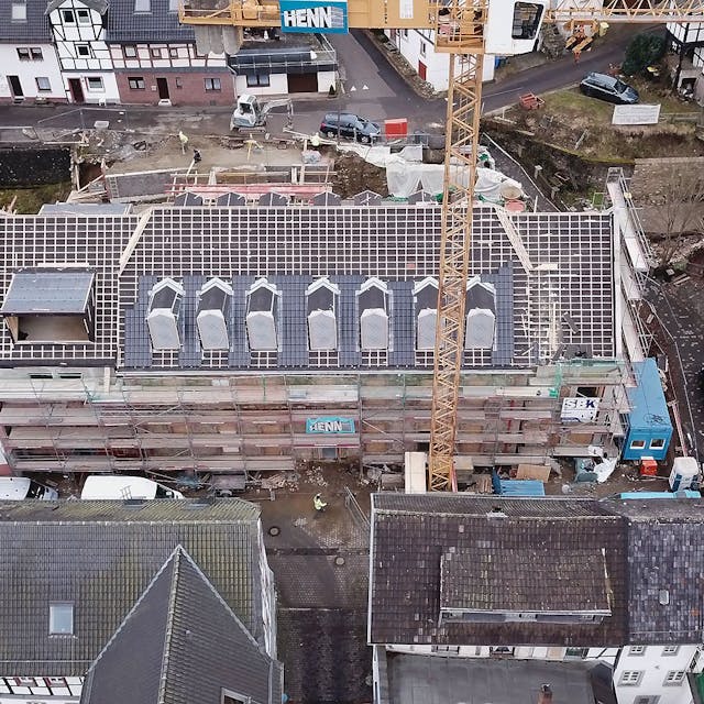 Das Luftbild zeigt das historische Gebäude an der Blankenheimer Ahrstraße. Das Haus ist eingerüstet, das Dach ist abgedeckt.