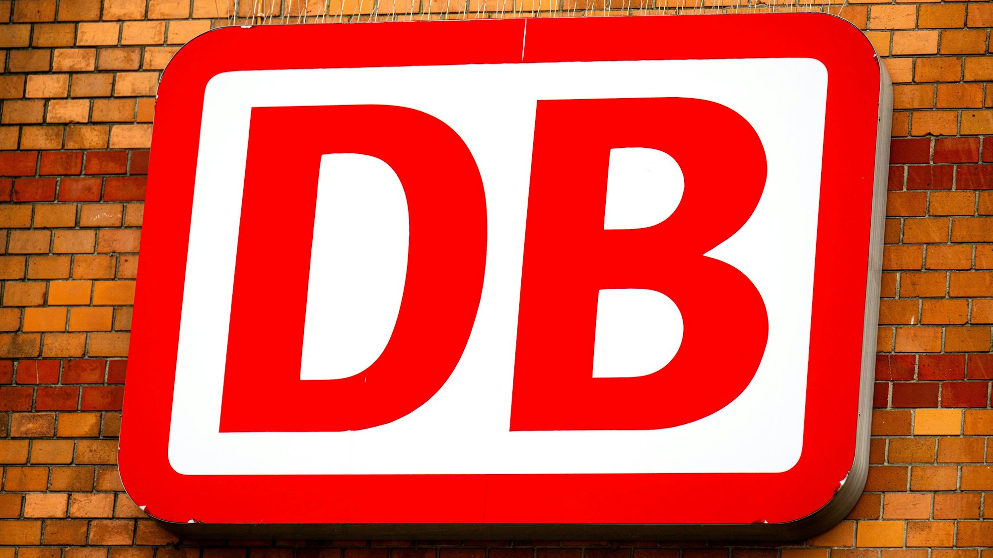 Ein Schild mit dem Logo der Deutschen Bahn (DB) leuchtet am Bremer Hauptbahnhof.