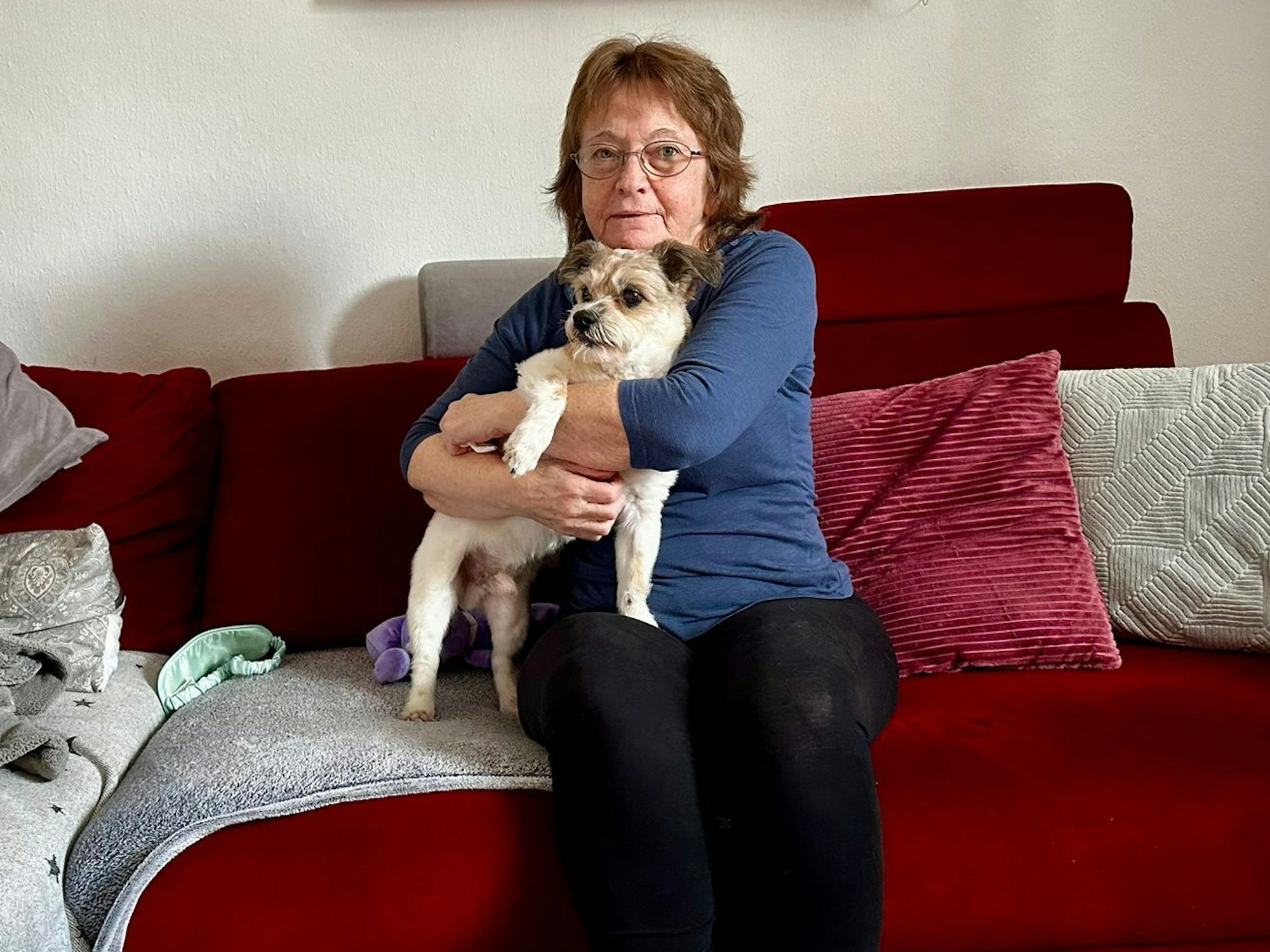 Roswitha Kirsch mit ihrem Hund Arko auf der Couch.