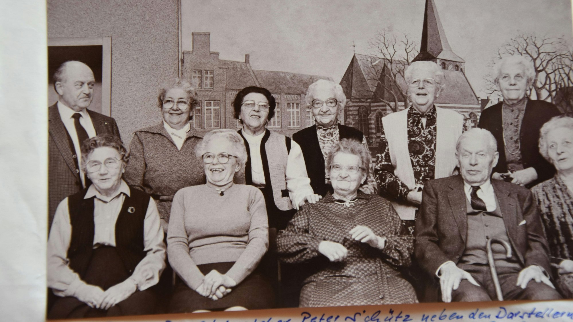 Ein altes Schwarz-Weiß-Foto zeigt eine Gruppe von älteren Frauen und Männern.
