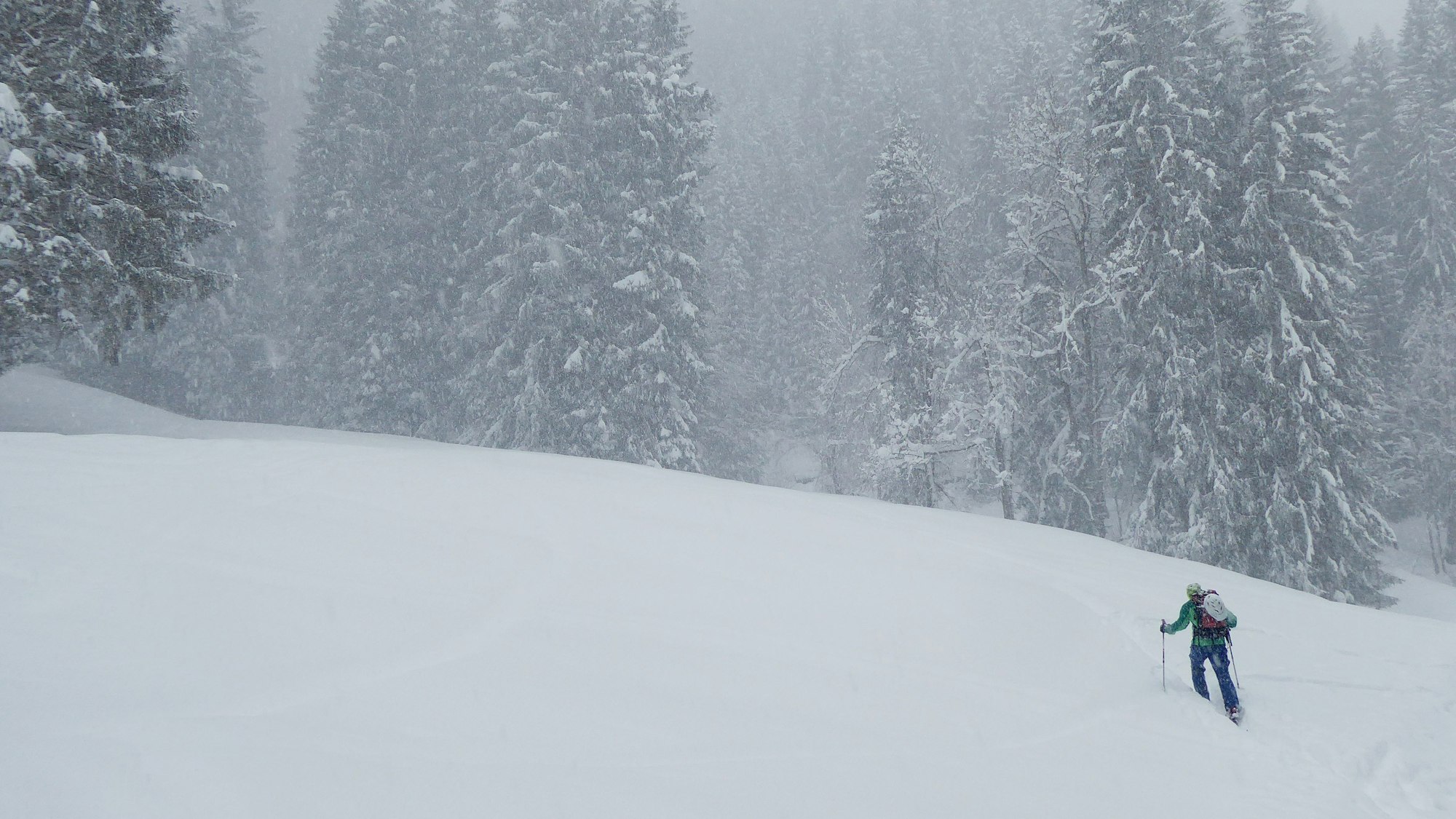 Ein Skitourengeher steigt durch viel Neuschnee einen Berg hinauf. (Symbolbild)