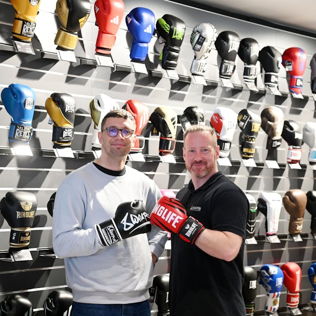 Mitinhaber Bruno Kabus (l.) und Geschäftsleiter Christoph Feldhaus vor der Wand mit 150 Boxhandschuh-Modellen