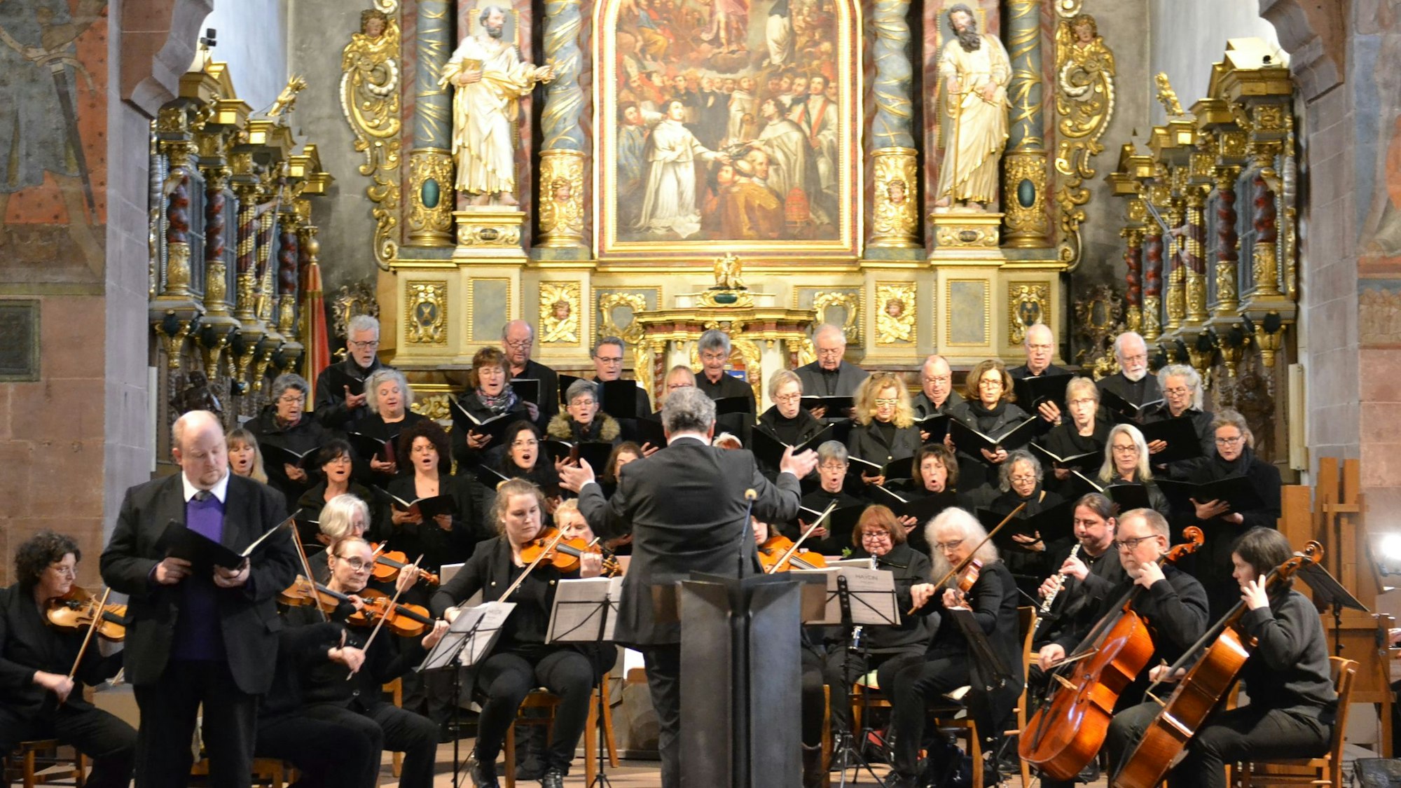 Orchester und Chor musizieren in der Basilika, im Hintergrund der Altar.