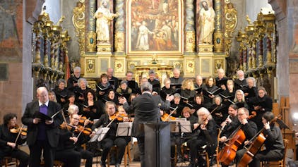 Orchester und Chor musizieren in der Basilika, im Hintergrund der Altar.
