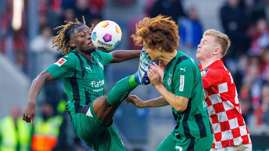 Borussia Mönchengladbachs Manu Koné tritt seinem Team-Kollegen Ko Itakura ins Gesicht.