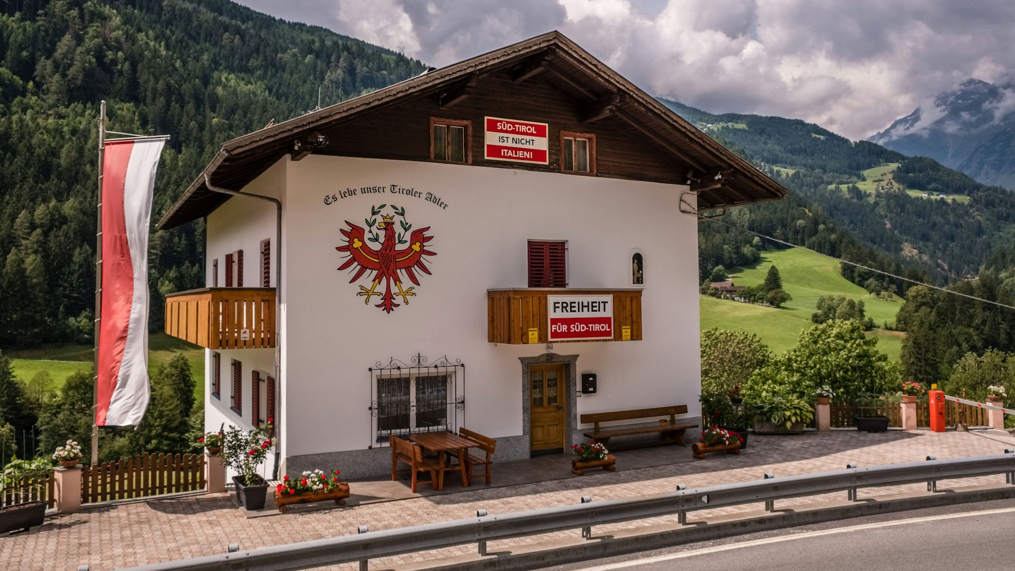 Ein Haus in Südtirol an dem Banner mit der Aufschrift "Freiheit für Südtirol" zu sehen sind.