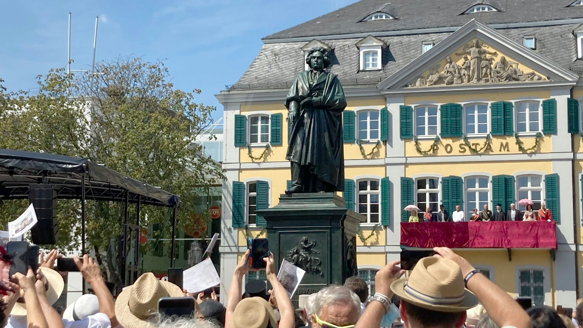 Schaulustige fotografieren und betrachten das Beethoven-Denkmal vor dem Hauptpostamt in Bonn.