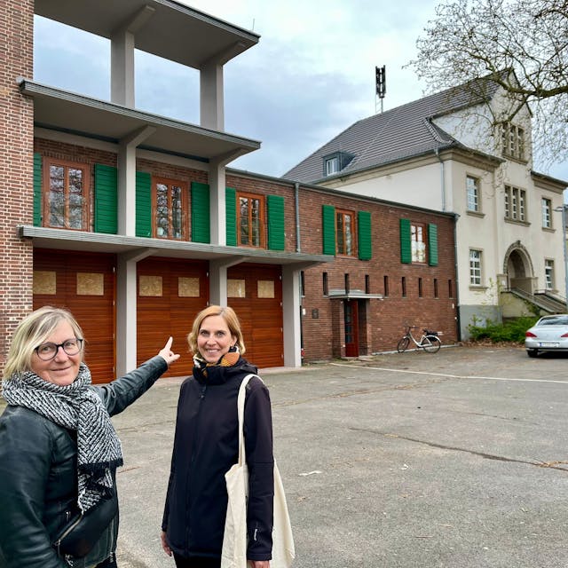 Andrea Pesch und Projektleiterin Kristina Gehrmann stehen vor der restaurierten Feuerwache in Bürrig.