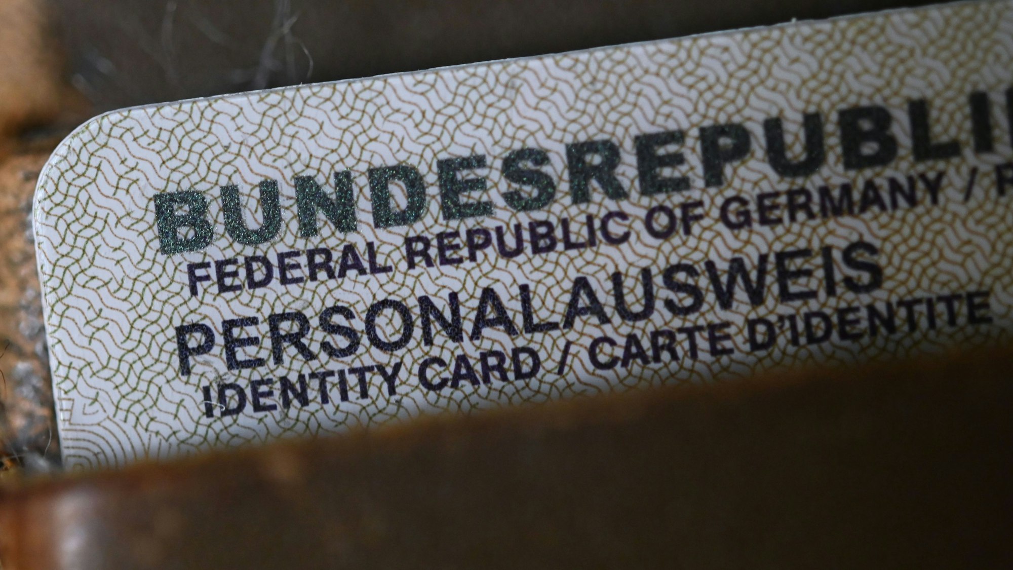 Ein Personalausweis der Bundesrepublik Deutschland steckt in einem Portemonnaie, nur die obere Ecke der Karte schaut heraus.