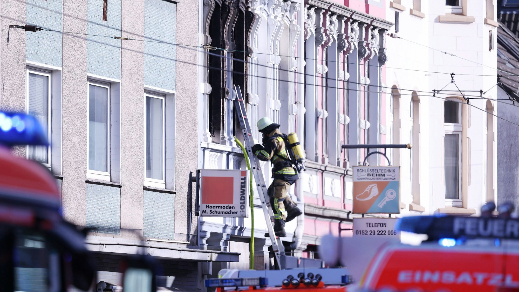 ARCHIV - 25.03.2024, Nordrhein-Westfalen, Solingen: Ein Feuerwehrmann klettert an einem Haus, in dem es gebrannt hat, auf einer Leiter.