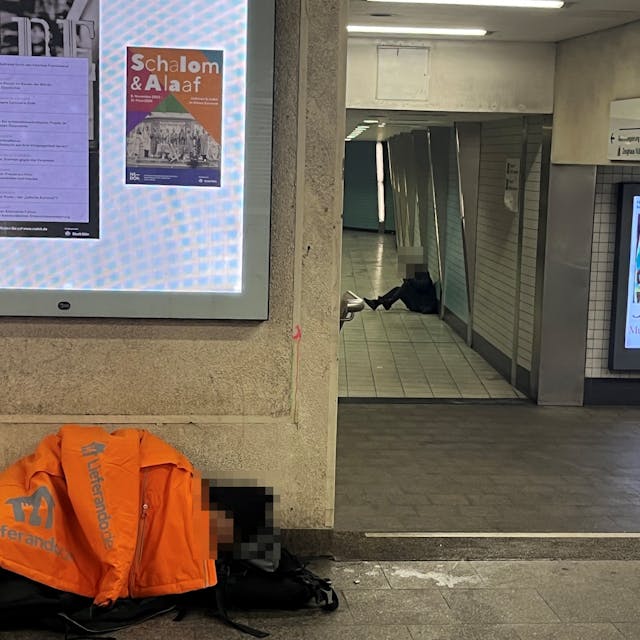 Obdachloser und Drogenabhängiger am Appellhofplatz liegen auf dem Boden.