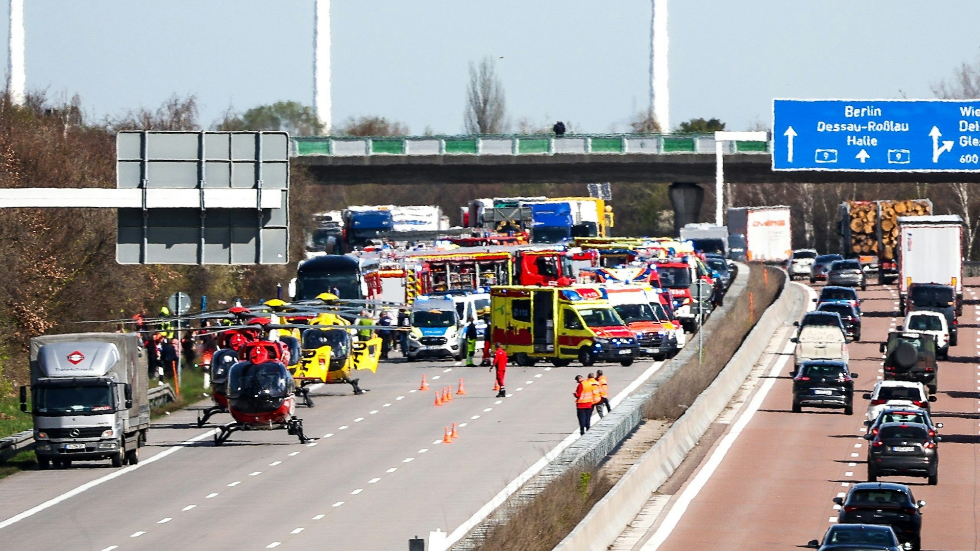 Einsatzfahrzeuge und Rettungshubschrauber stehen auf der A9 an der Unfallstelle.