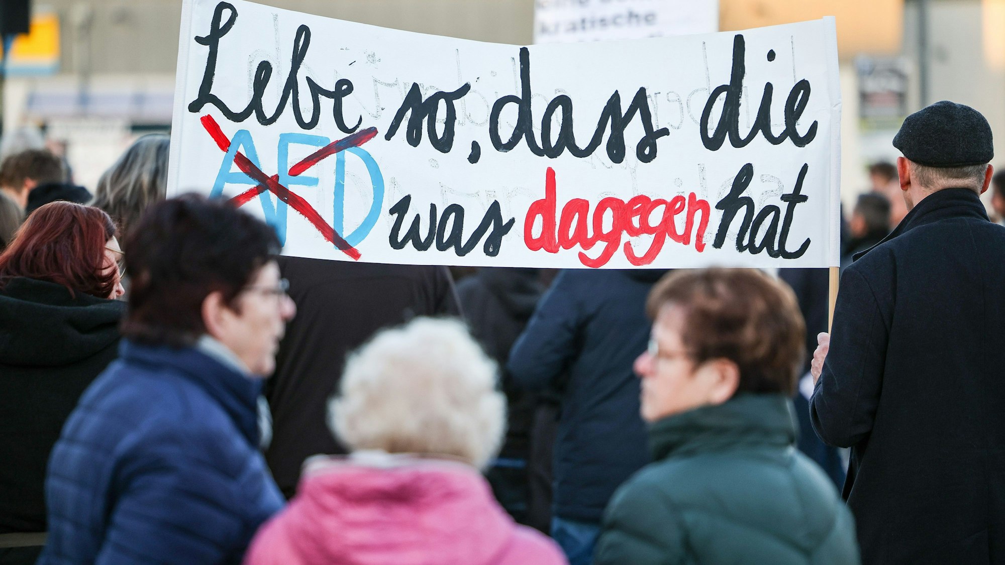 Teilnehmer einer Protestveranstaltung gegen eine AfD-Demonstration in Bad Bibra (Sachsen-Anhalt) halten ein Transparent «Lebe so, dass die AfD was dagegen hat».