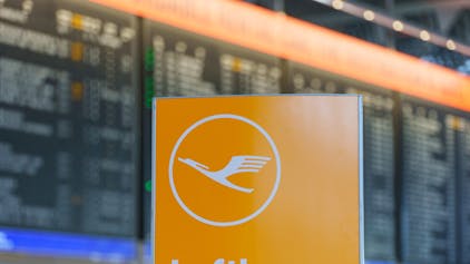 ARCHIV - 06.03.2024, Hessen, Frankfurt/Main: Das Logo der Fluggesellschaft Lufthansa steht vor der Anzeigetafel in der Abflughalle im Terminal 1.&nbsp;