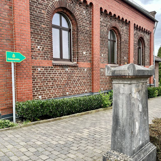Hinweistafel „Gedenkstätte“ an der Friedhofskapelle in Burscheid