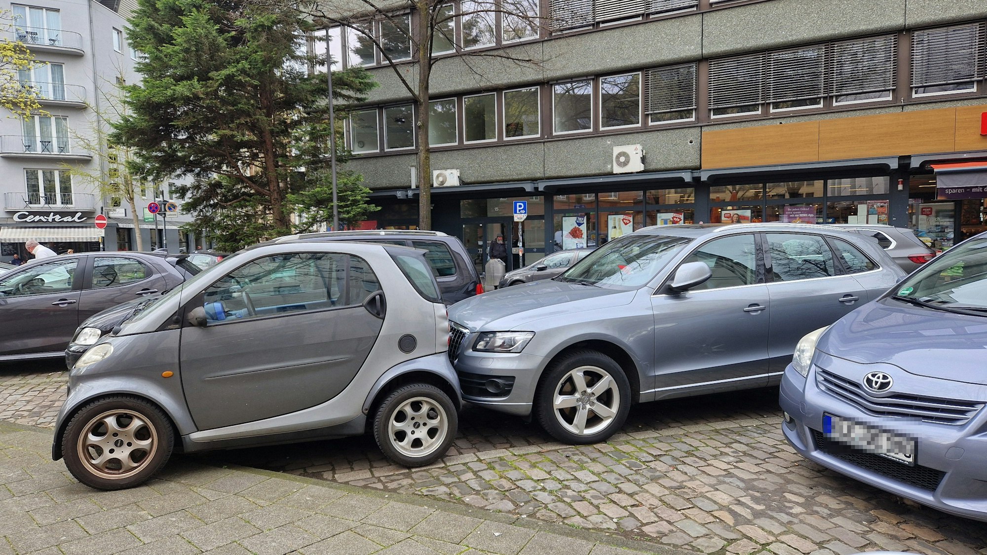 Ein Smart und ein Audi teilen sich auf engstem Raum einen Parkplatz.