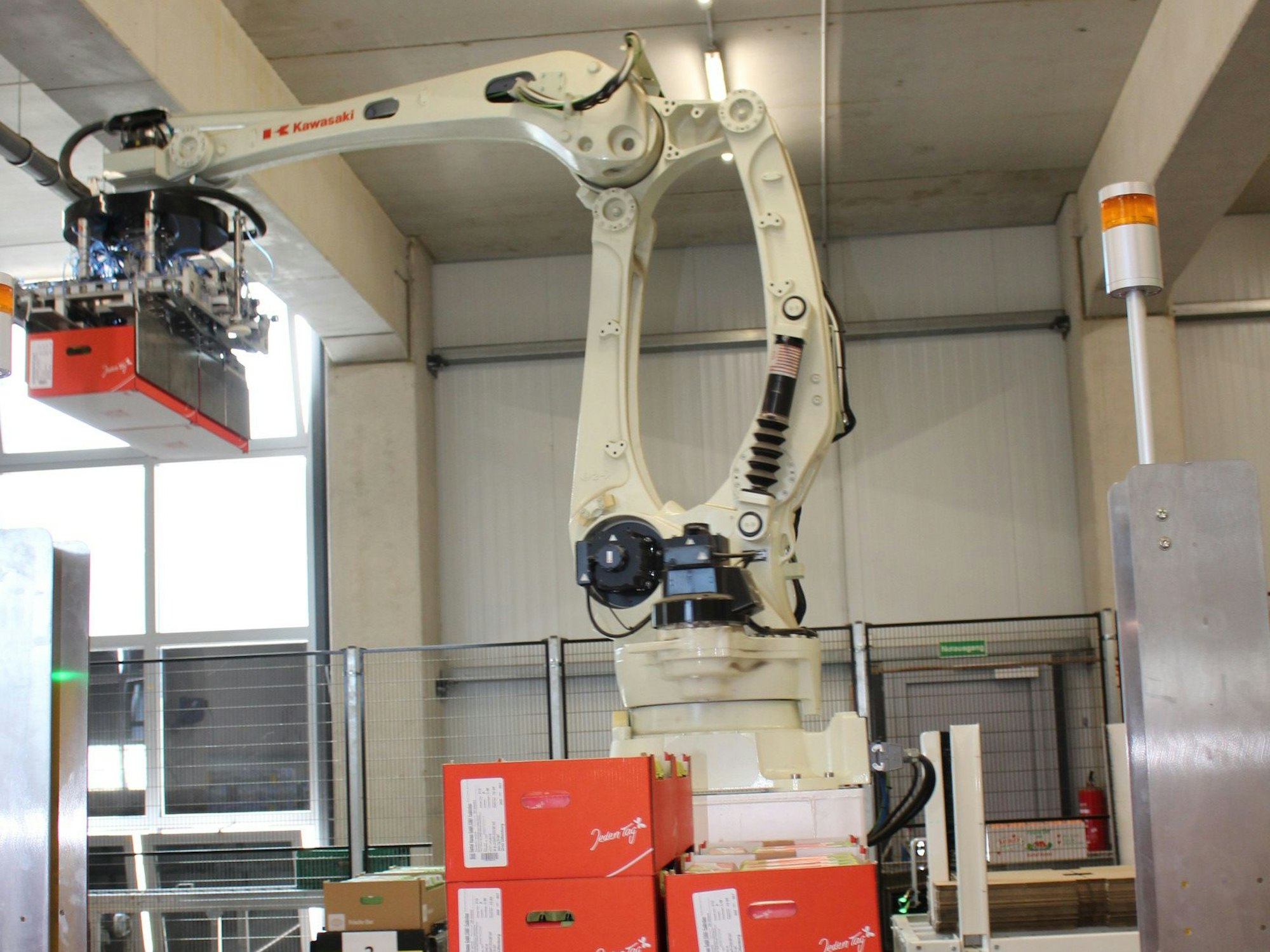 Ein Roboterarm hebt eine Packung mit Eiern an, um sie auf einem Stapel legen.