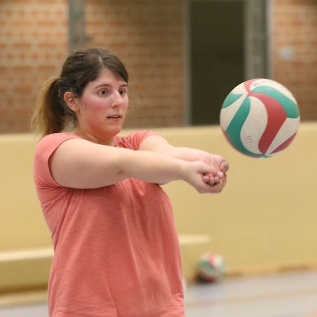 Julia Reuß fokussiert einen Volleyball und hat die Arme zum Baggern ausgestreckt, die Hände sind ineinander geschoben.&nbsp;