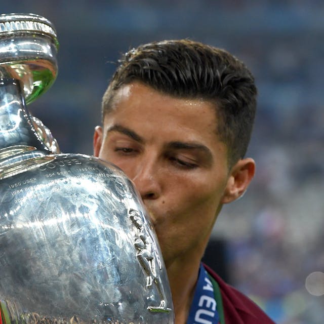 Auf dem Foto ist der portugiesische Nationalspieler Christiano Ronaldo zu sehen. Er küsst den EM-Pokal.