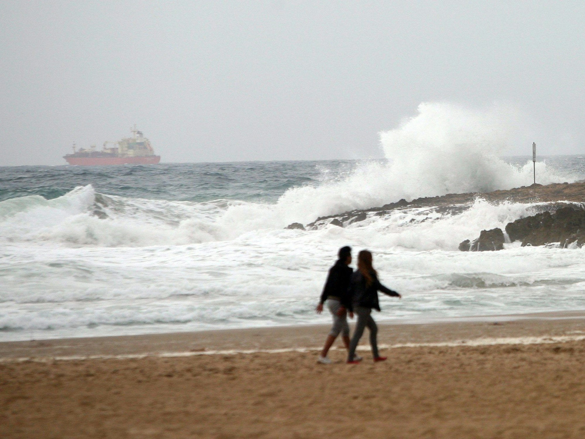 Ein Paar läuft am Strand von Tarragona.