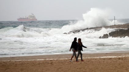 Ein Paar läuft am Strand von Tarragona.