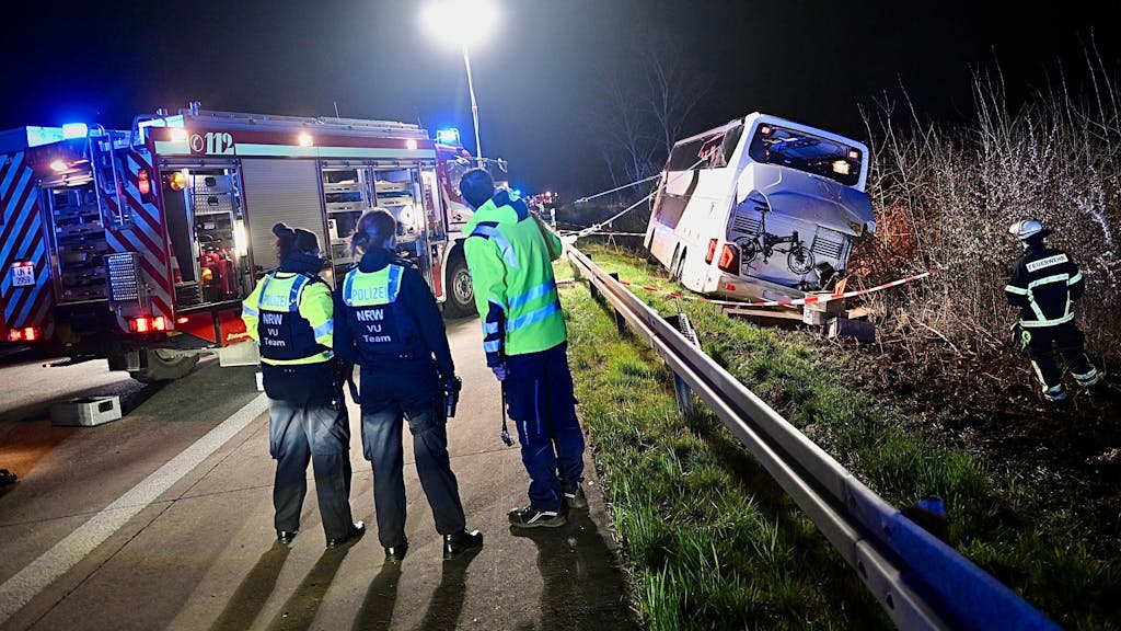 Einsatzkräfte der Feuerwehr und Polizei arbeiten am frühen Morgen des 29. März 2024 an einer Unfallstelle auf der Autobahn 44 bei Werl an einem verunfallten Bus.