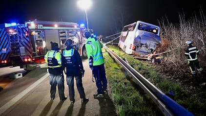 Einsatzkräfte der Feuerwehr und Polizei arbeiten am frühen Morgen des 29. März 2024 an einer Unfallstelle auf der Autobahn 44 bei Werl an einem verunfallten Bus.