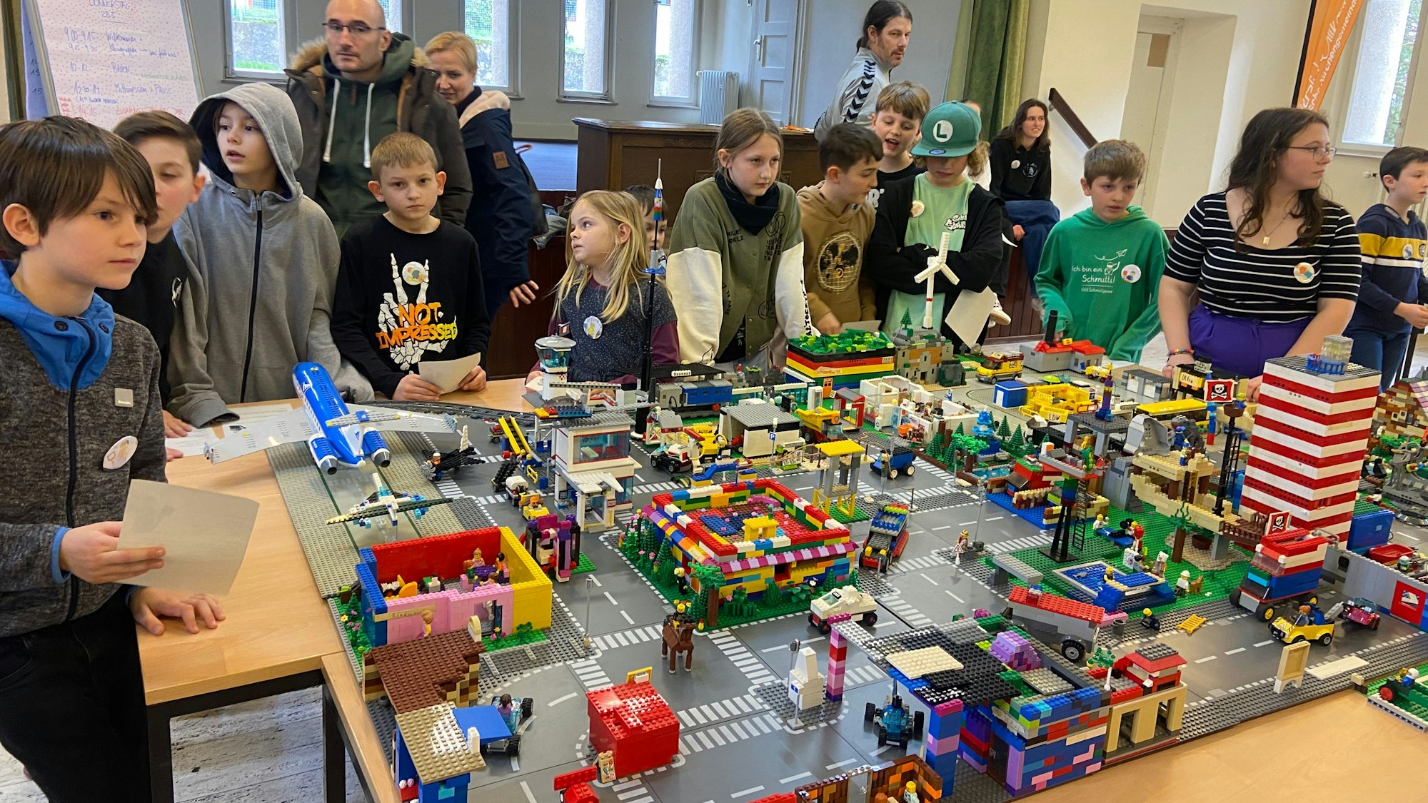 Kinder stehen um eine Lego-Stadt herum
