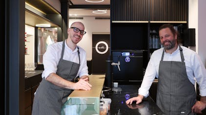 Zwei Männer stehen im Kölner Restaurant Ottio an einer Theke.