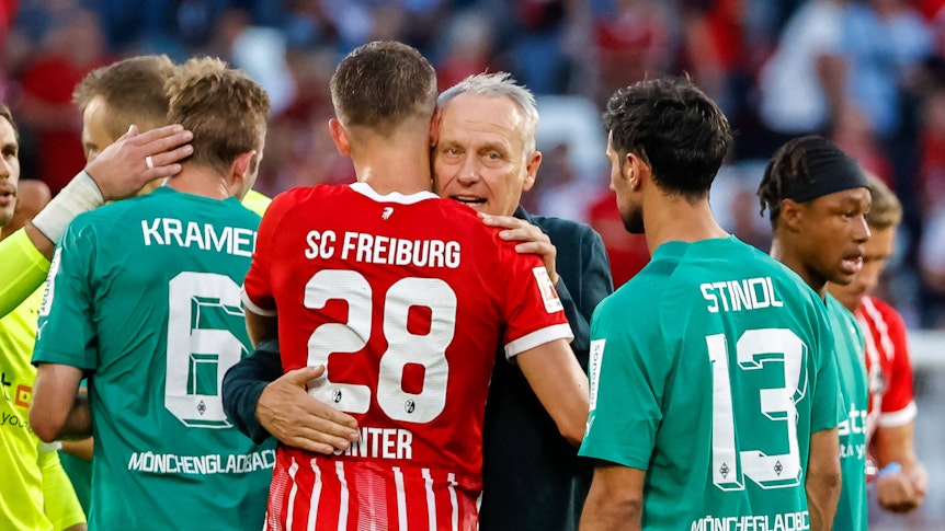 Trainer vom SC Freiburg umarmt einen seiner Spieler nach einer Partie gegen Borussia Mönchengladbach.