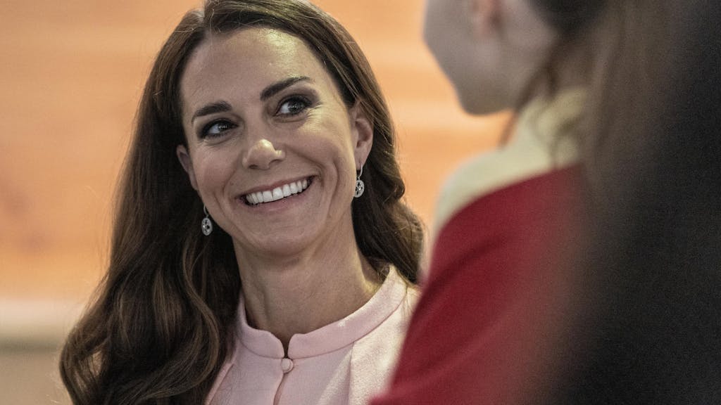 Prinzessin Kate lächelt ein Mädchen an.