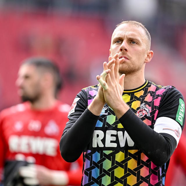 Marvin Schwäbe, Torhüter des 1. FC Köln, applaudiert nach dem 1:1 beim FC Augsburg den mitgereisten Fans.