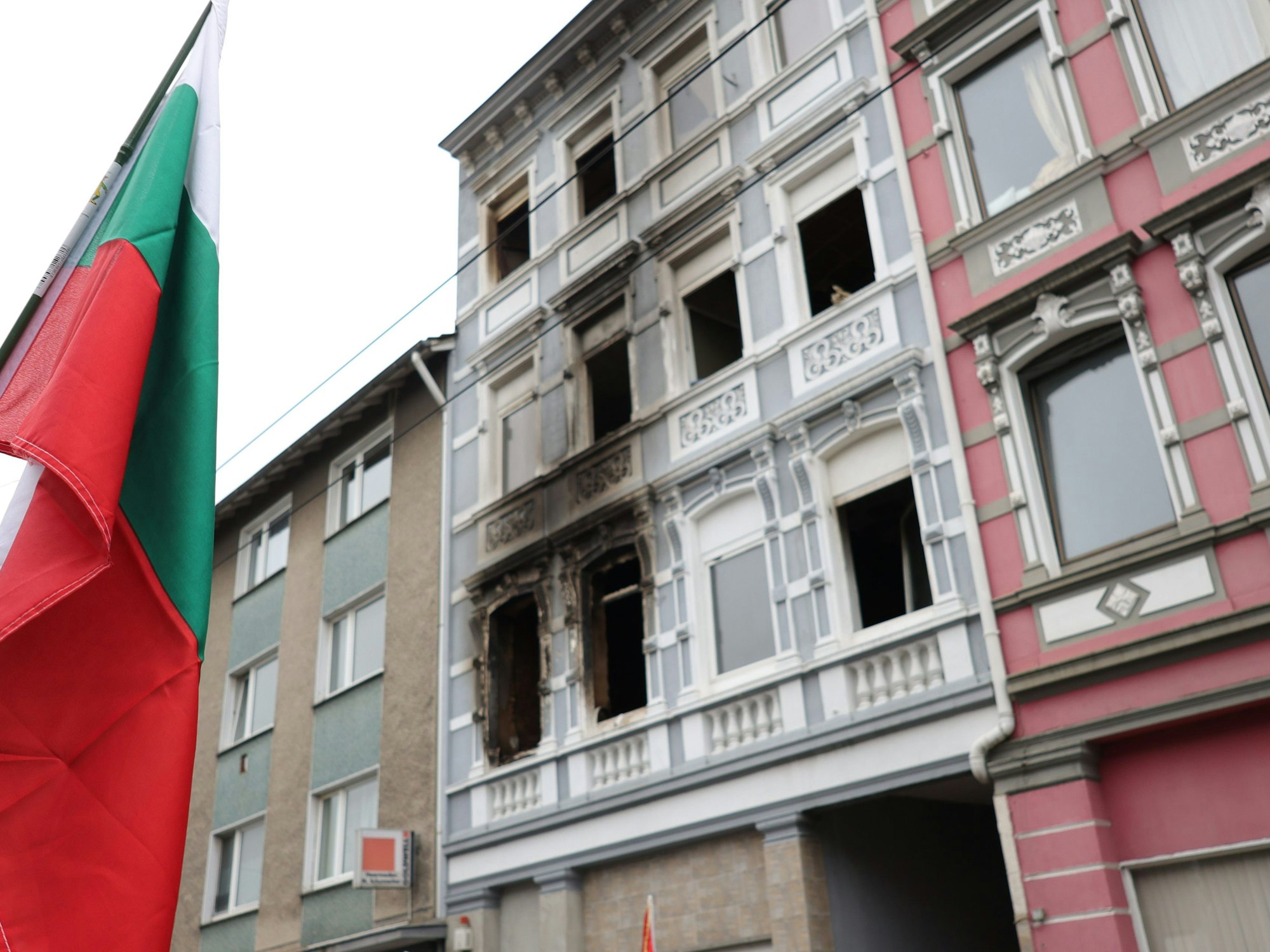 30. März 2024 in Solingen, NRW: Eine bulgarische Fahne steht vor dem ausgebrannten Haus, in dem eine aus Bulgarien stammende Familie ums Leben kam.