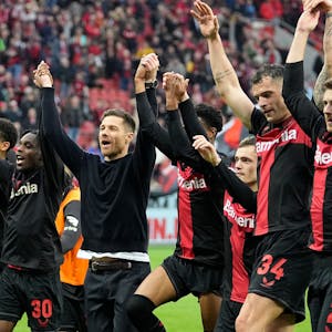 Leverkusen's head coach Xabi Alonso, center, celebrates with his team in front of supporters after winning the German Bundesliga soccer match between Bayer Leverkusen and TSG Hoffenheim at the BayArena in Leverkusen, Germany, Saturday, March 30, 2024. (AP Photo/Martin Meissner)